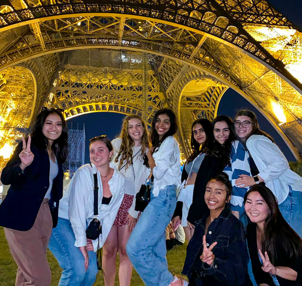 UH study abroad students posing under the Eiffel Tower